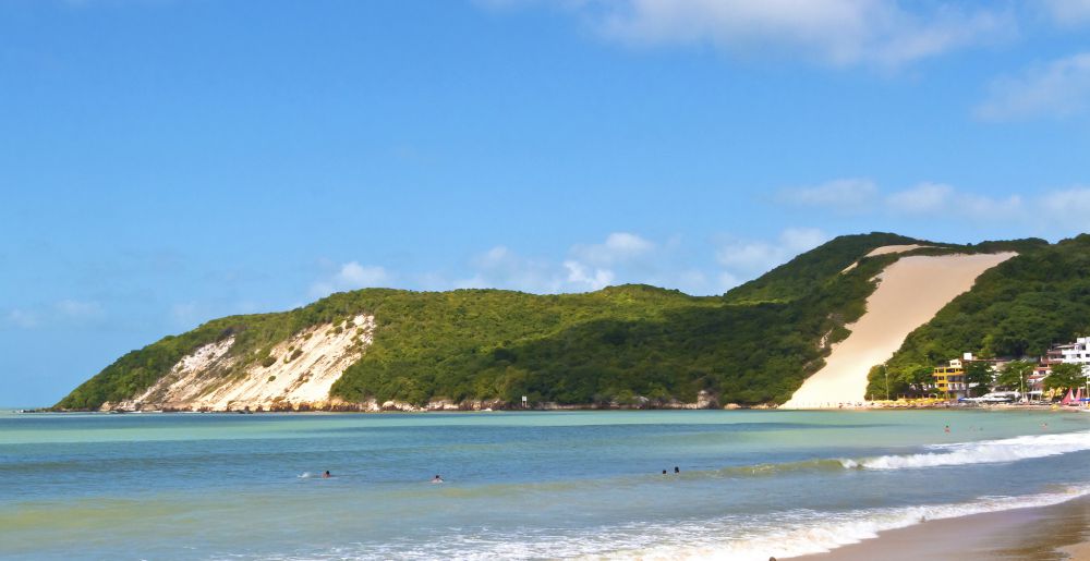 Vista da Praia de Ponta Negra em Natal - RN, com destaque para o icônico Morro do Careca e suas águas tranquilas.