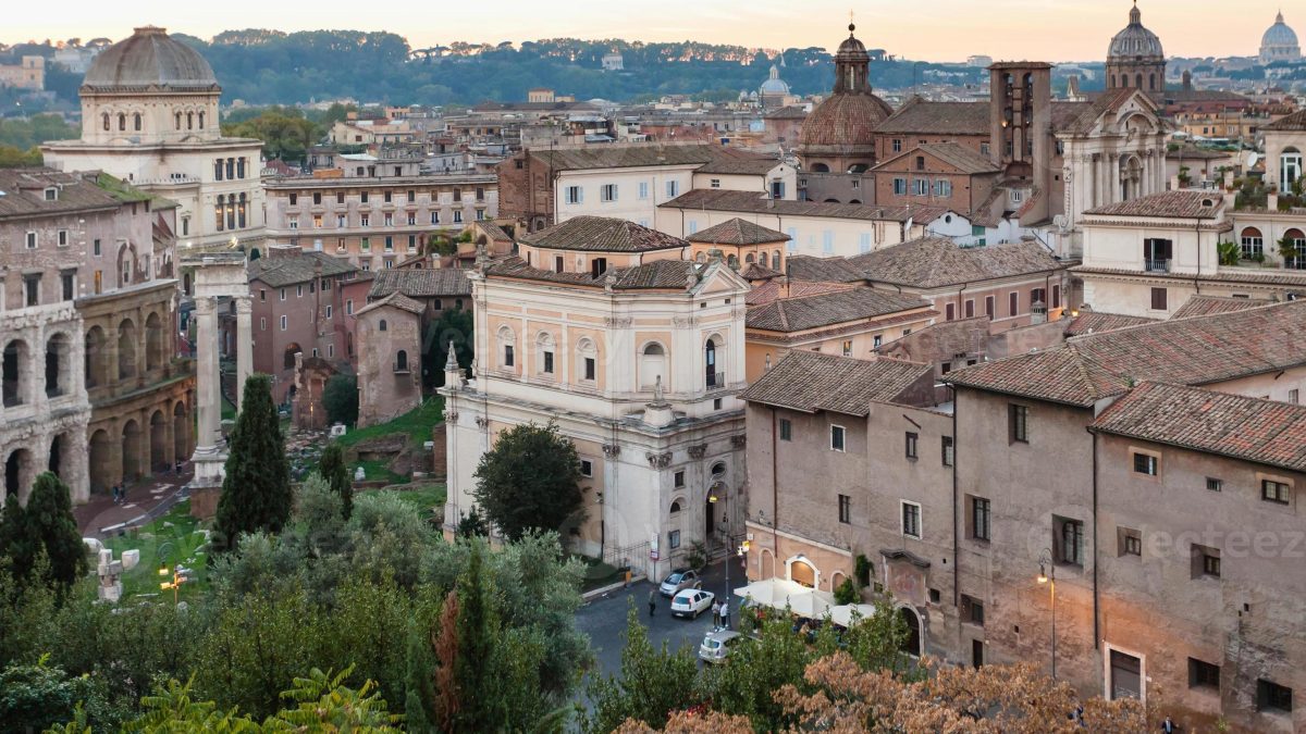 Vista panorâmica da Colina Capitolina, uma das Sete Colinas de Roma, destacando a arquitetura histórica e os marcos culturais que dominam a paisagem urbana. Ao fundo, a rica tapeçaria da cidade revela a majestade de Roma, com suas cúpulas e edifícios antigos contrastando com o verde das árvores.